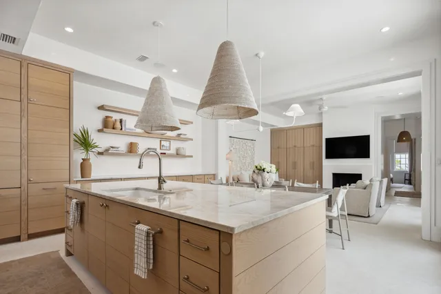 a kitchen with stainless steel appliances granite countertop white cabinets and a potted plant