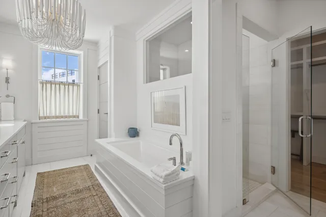 a spacious en suite bathroom with a double vanity sink a large mirror and a shower