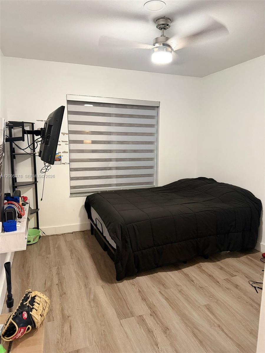 16314 Southwest 97th Street Miami, FL 33196 - Photo 29 of 41 a bedroom with a bed and wooden floor