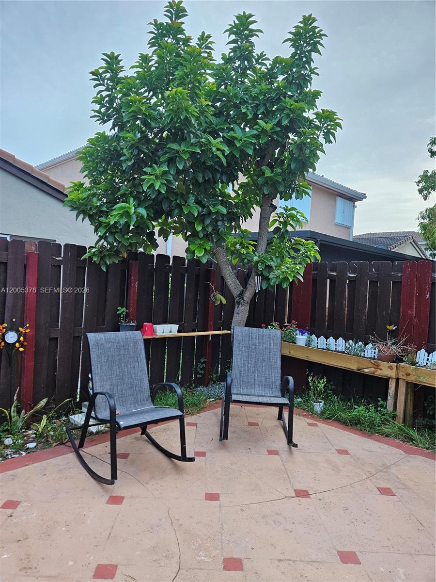 16314 Southwest 97th Street Miami, FL 33196 - Photo 36 of 41 a table and chair sitting in a backyard with wooden fence