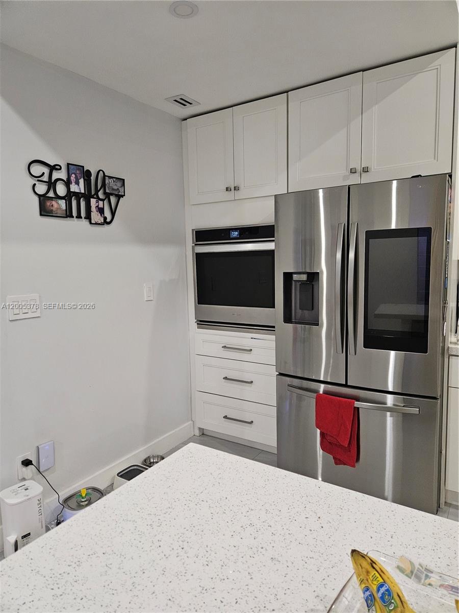 16314 Southwest 97th Street Miami, FL 33196 - Photo 6 of 41 a kitchen with kitchen island white cabinets and stainless steel appliances