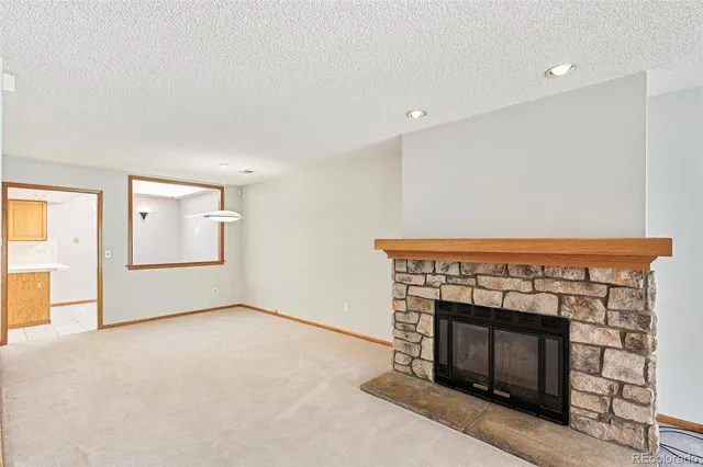 an empty room with windows and fireplace