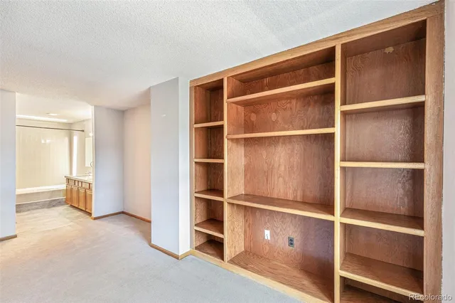 a view of an empty room with cabinet and a window