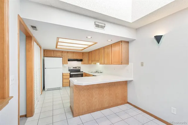 a kitchen with a sink a stove cabinets and a window
