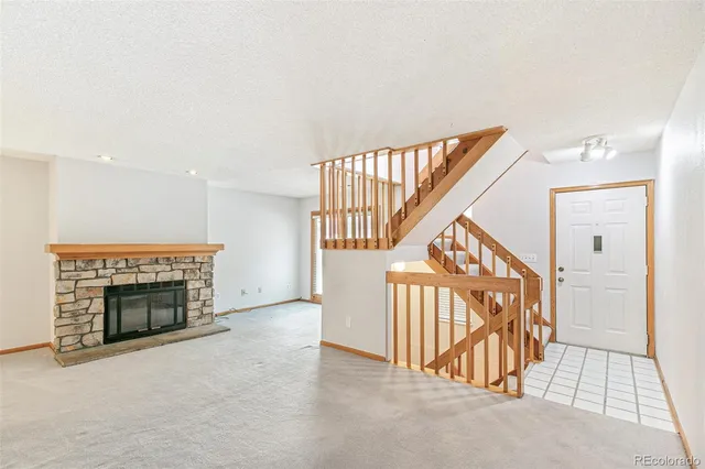 an entryway with an empty room and fire place
