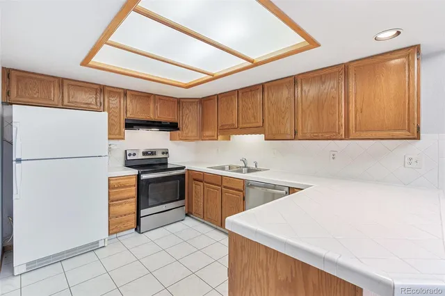 a kitchen with a sink a stove a refrigerator and cabinets