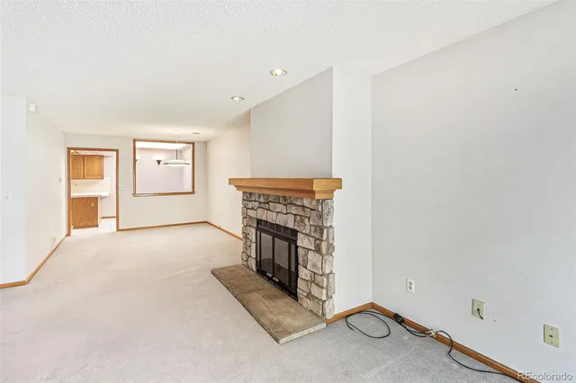 a view of an empty room with a fireplace and a window