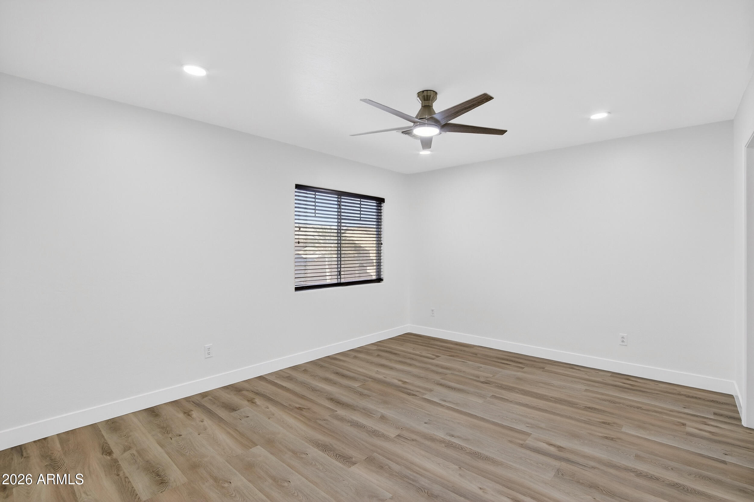 43620 West Cowpath Road Maricopa, AZ 85138 - Photo 42 of 60 an empty room with wooden floor fan and windows