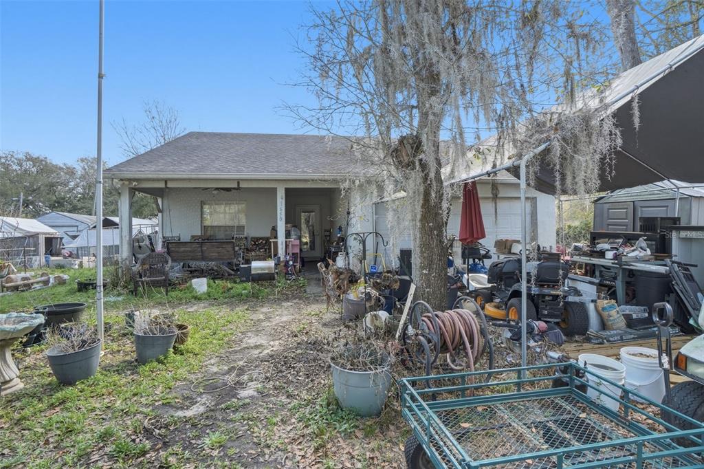 1650 East Welch Road Apopka, FL 32712 - Photo 6 of 29 a view of a patio with table and chairs potted plants and a large tree