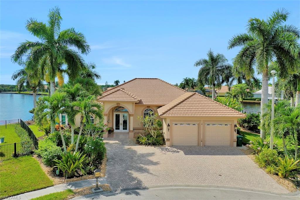 134 Windward Cay Naples, FL 34114 - Photo 12 of 35 a front view of a house with a yard and garage