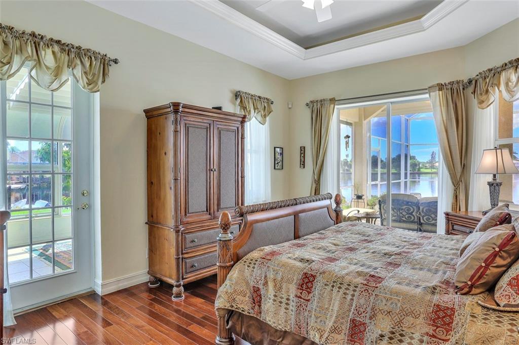 134 Windward Cay Naples, FL 34114 - Photo 14 of 35 a bedroom with a bed and wooden floor