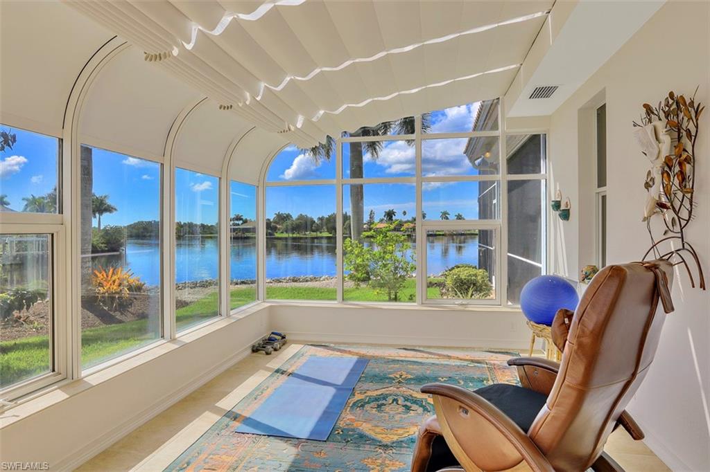 134 Windward Cay Naples, FL 34114 - Photo 16 of 35 a living room with furniture and a floor to ceiling window