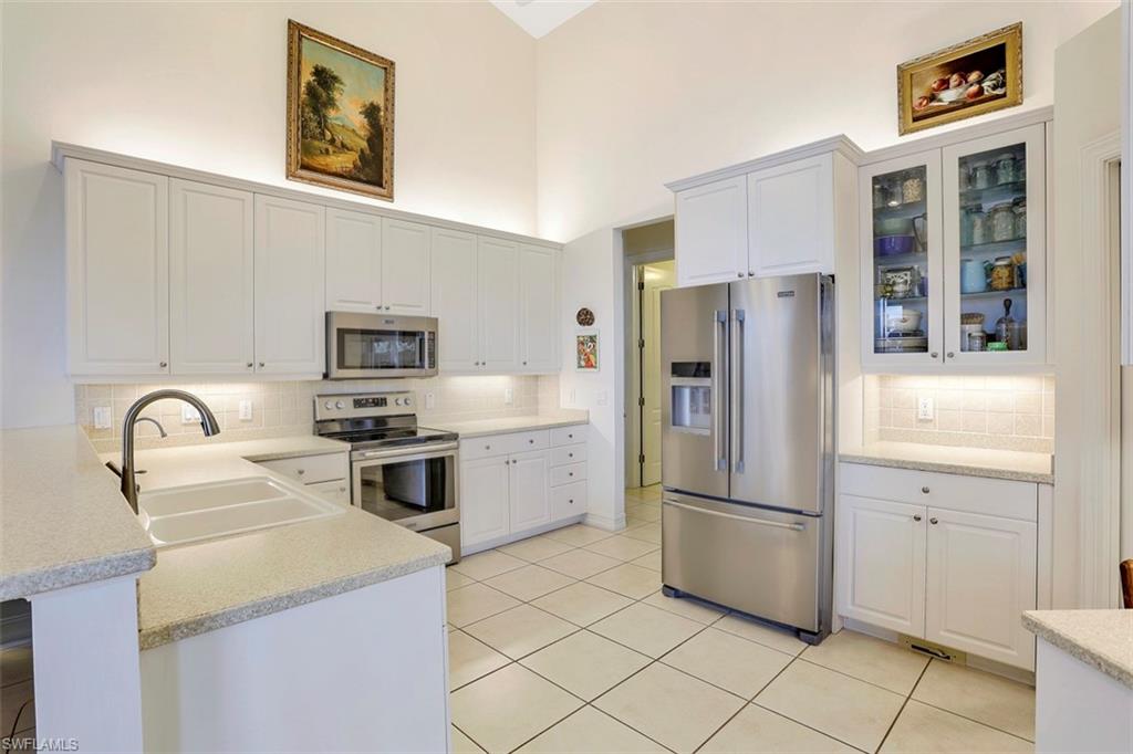 134 Windward Cay Naples, FL 34114 - Photo 29 of 35 a kitchen with stainless steel appliances a refrigerator sink and cabinets