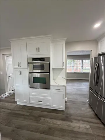a kitchen with granite countertop a refrigerator and a stove top oven