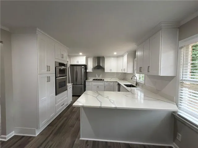 a large white kitchen with a large window