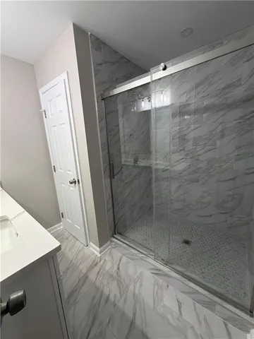 a bathroom with a shower and a glass door