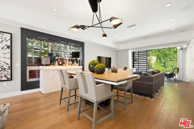 a dining room with furniture a chandelier and wooden floor