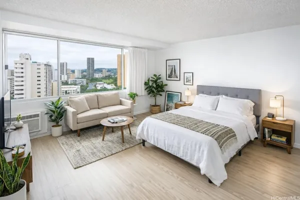 a spacious bedroom with a bed a couch and a large window