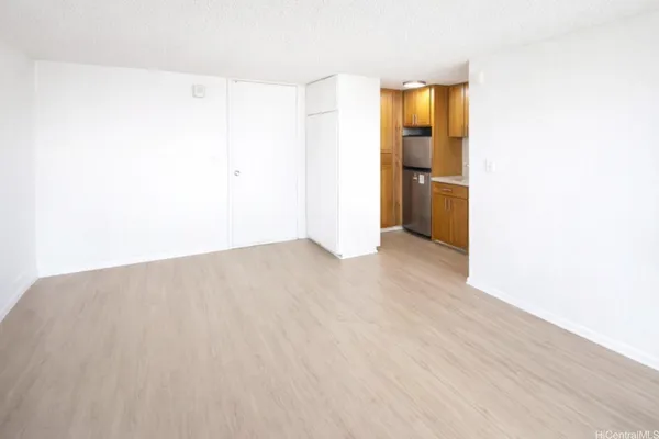 a view of empty room with wooden floor