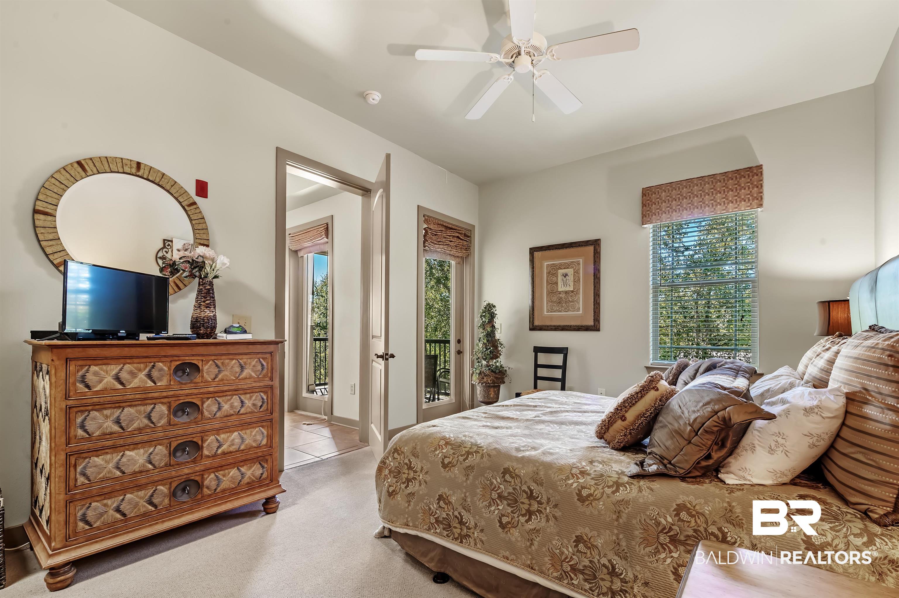1430 Regency Road, Unit A301 Gulf Shores, AL 36542 - Photo 21 of 47 Bedroom with light carpet, multiple windows, access to outside, and ceiling fan