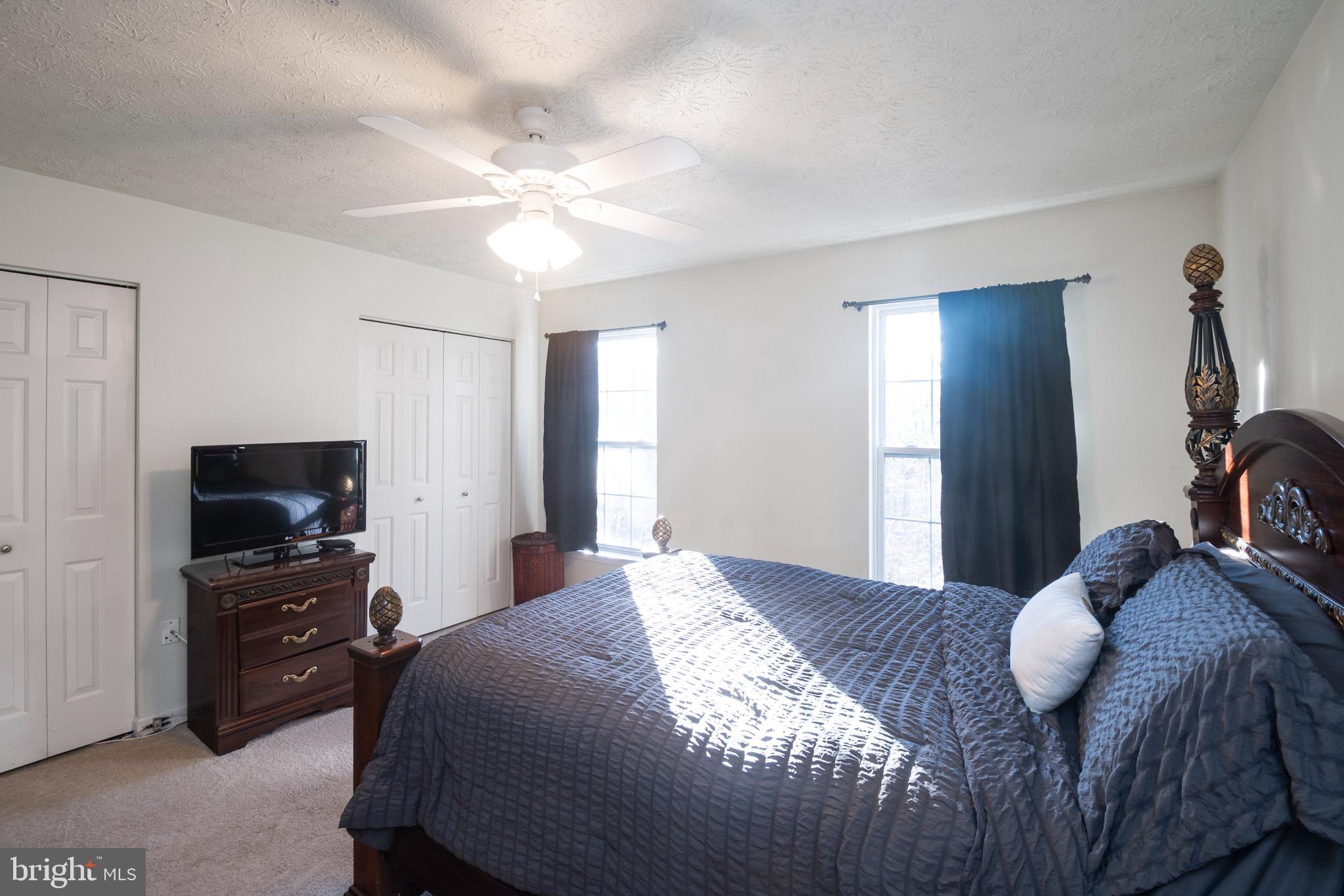 8310 Water Lily Way Laurel, MD 20724 - Photo 11 of 31 a bedroom with a bed and a flat tv screen on dresser