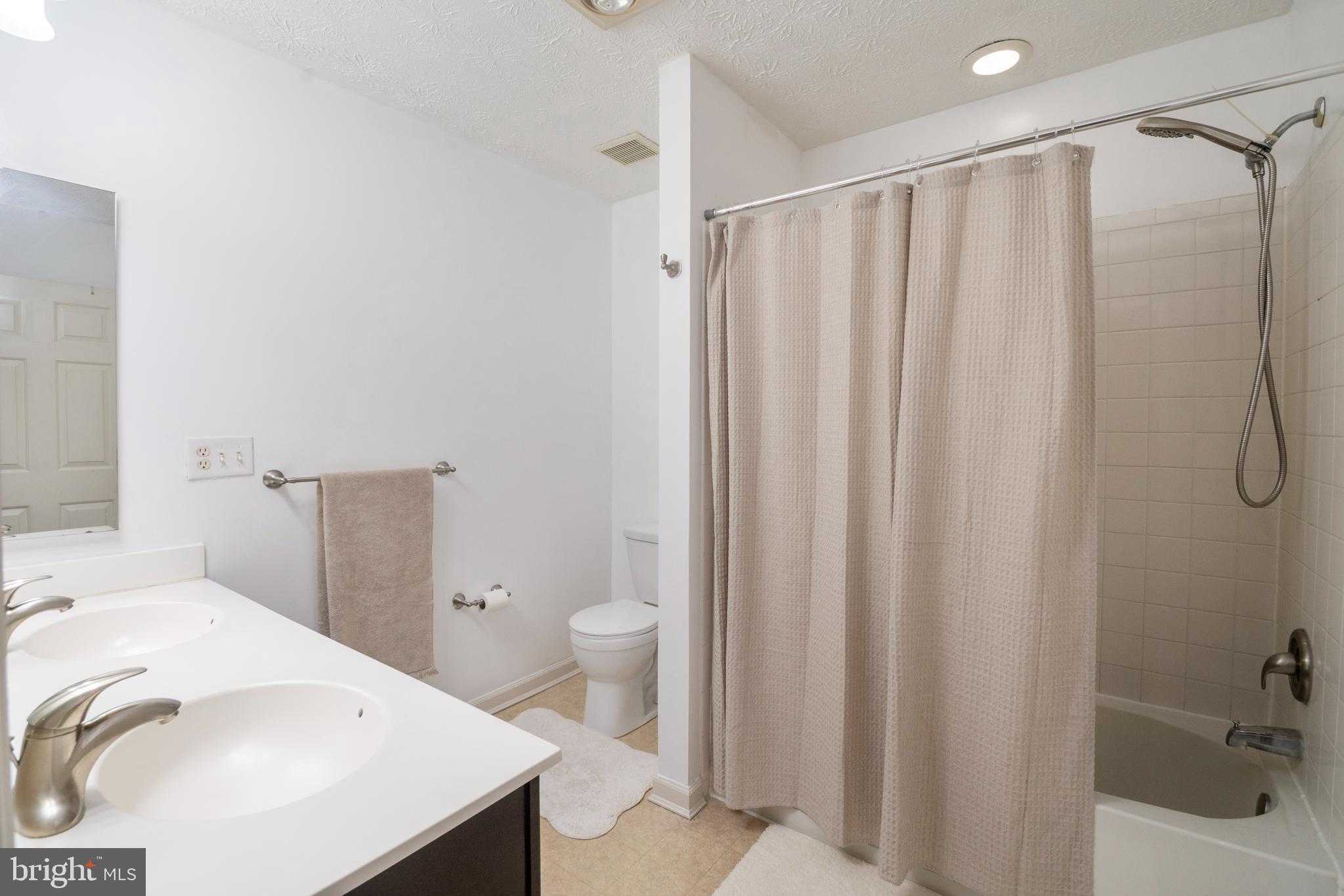8310 Water Lily Way Laurel, MD 20724 - Photo 14 of 31 a bathroom with a sink a toilet and shower curtain