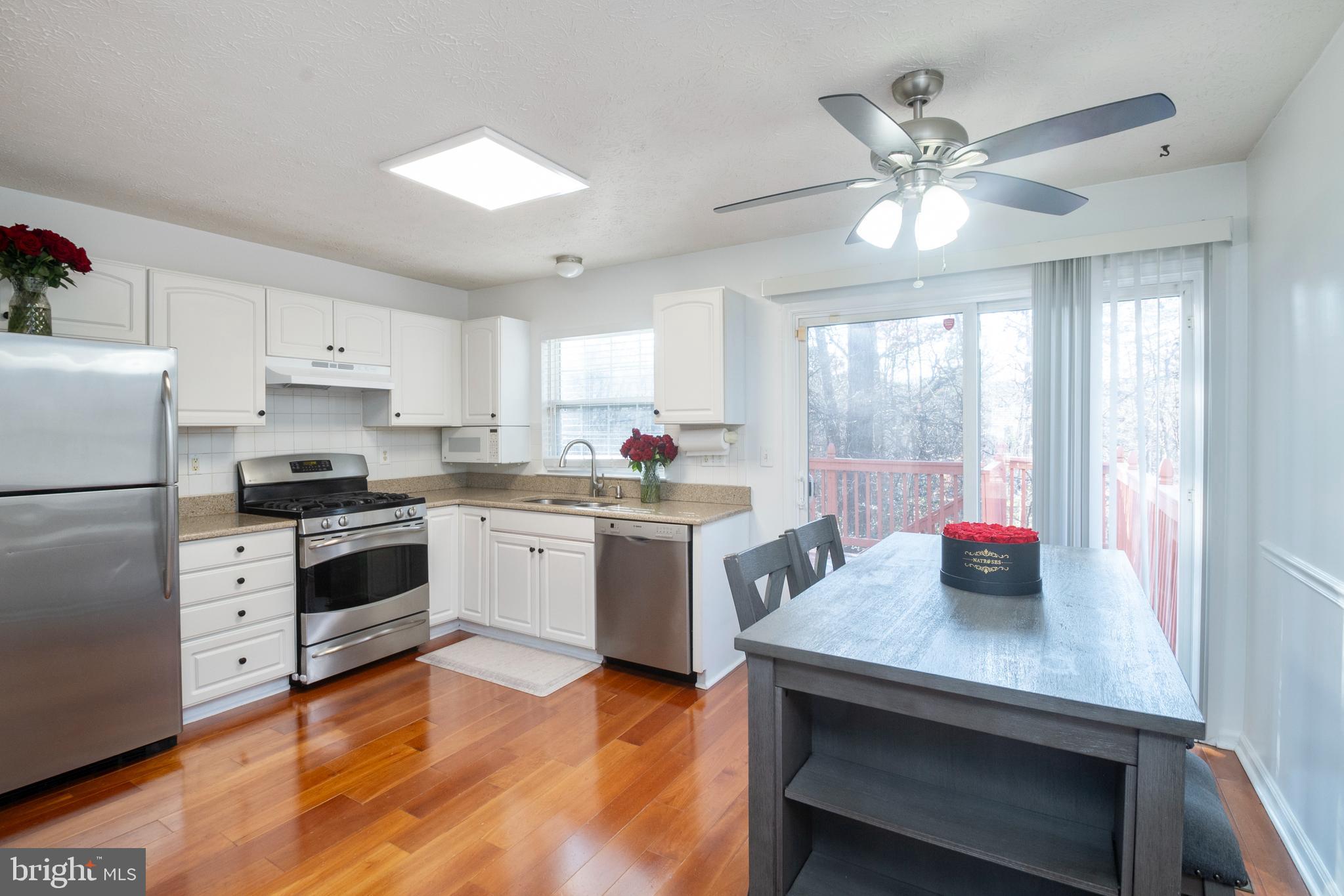 8310 Water Lily Way Laurel, MD 20724 - Photo 5 of 31 a kitchen with a refrigerator a sink dishwasher with a dining table and chairs