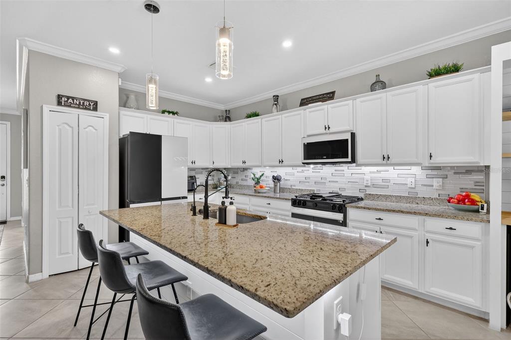 17619 Blue Rdg Place Bradenton, FL 34211 - Photo 7 of 98 a kitchen with stainless steel appliances granite countertop a kitchen island hardwood floor sink stove and microwave