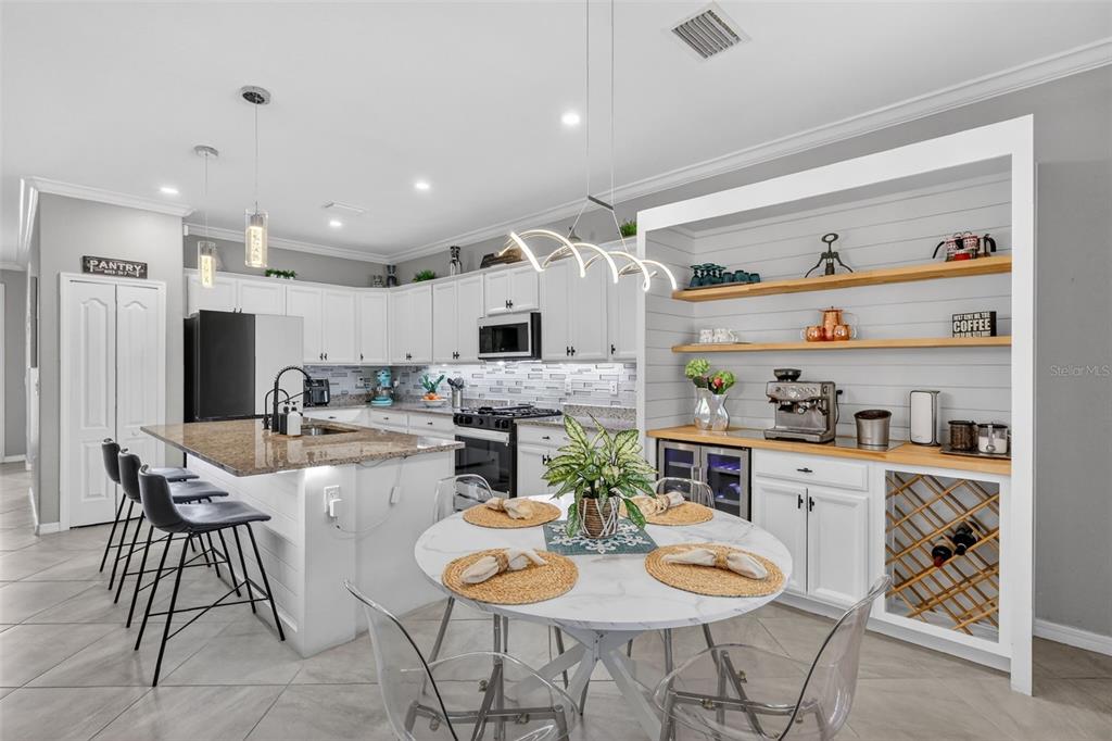 17619 Blue Rdg Place Bradenton, FL 34211 - Photo 8 of 98 a kitchen with stainless steel appliances kitchen island granite countertop a dining table and chairs