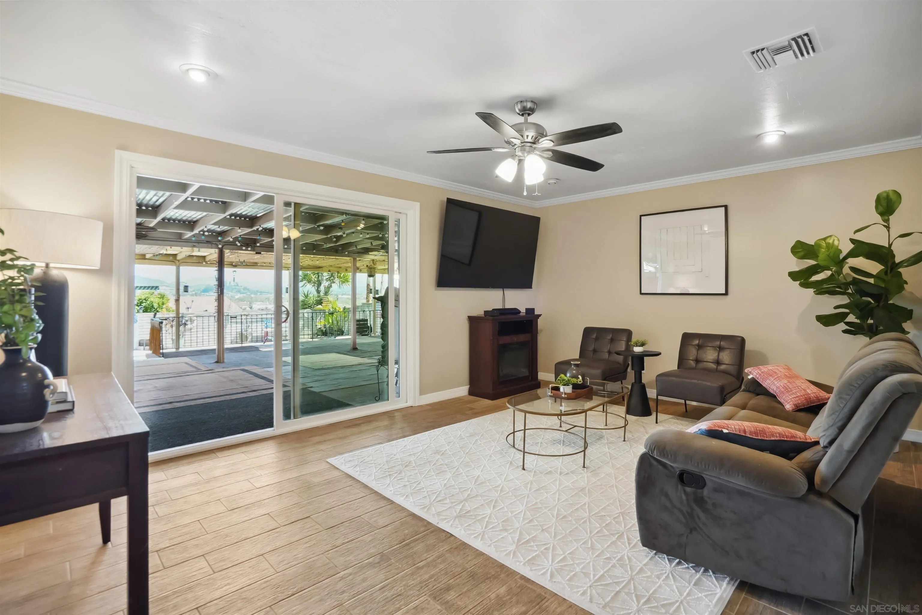 9537 East Hartland Circle Santee, CA 92071 - Photo 2 of 42 a living room with furniture a fireplace and a floor to ceiling window
