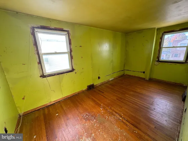 a view of a room with wooden floor and windows