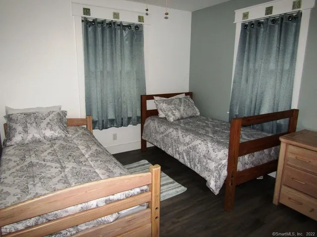 a bedroom with bed and wooden floor