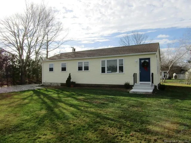a view of a house with a yard and sitting area