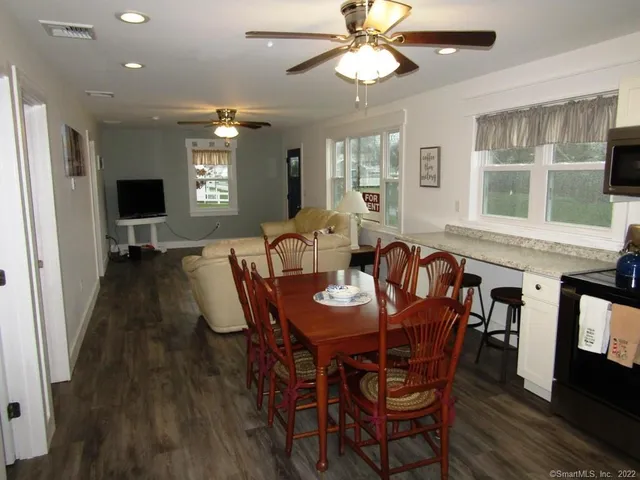 a view of a a dining room with furniture window and wooden floor