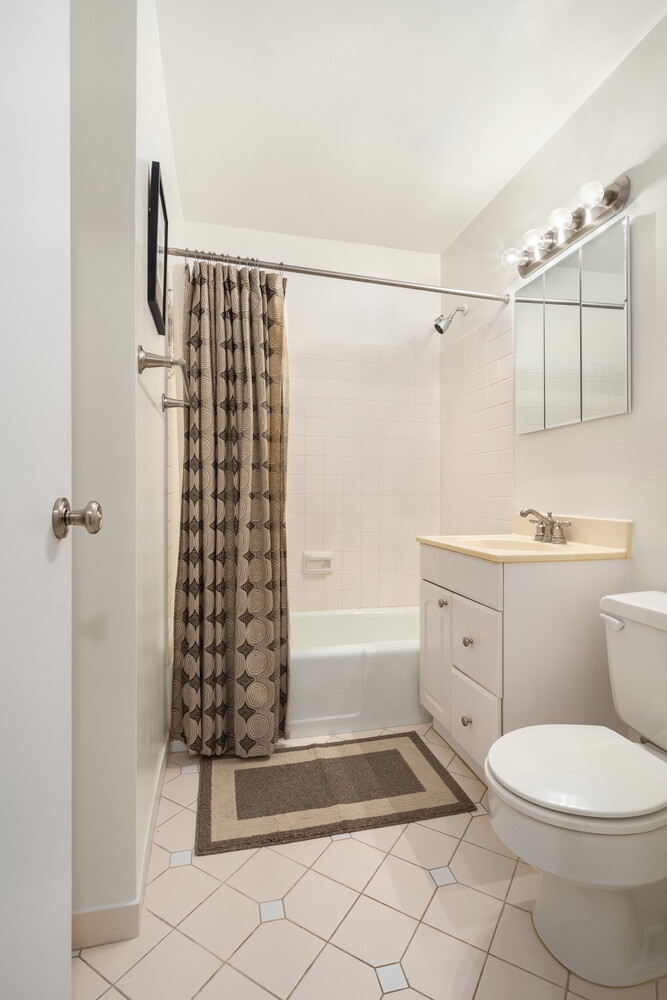 200 West 79th Street, Unit 16S Manhattan, NY 10024 - Photo 7 of 9 a bathroom with a sink a toilet and shower