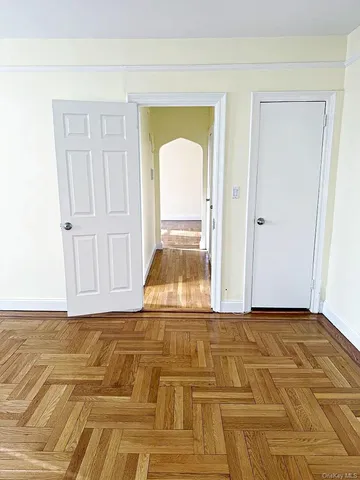 a view of a livingroom with wooden floor and a bathroom