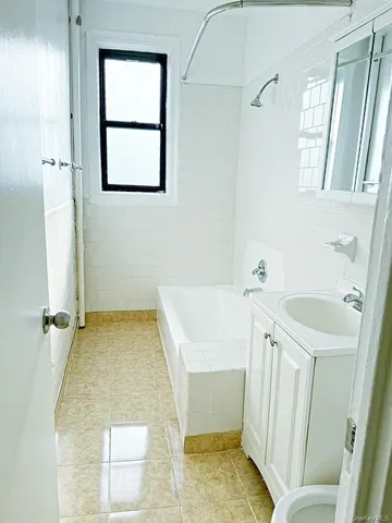a bathroom with a tub sink and a mirror