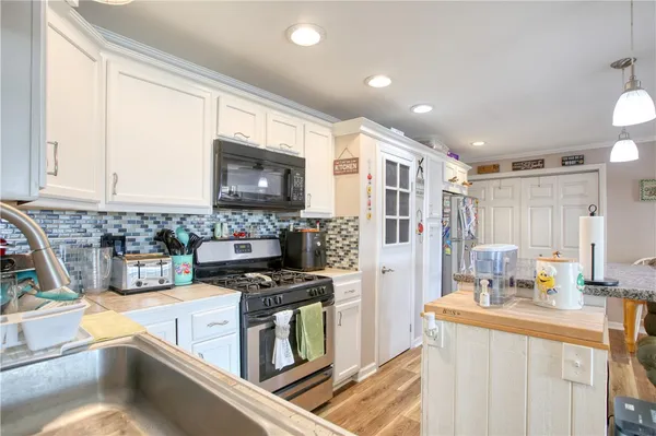 a kitchen with stainless steel appliances granite countertop a refrigerator and a stove top oven