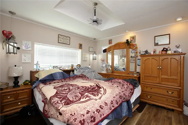 a bedroom with bed and wooden floor