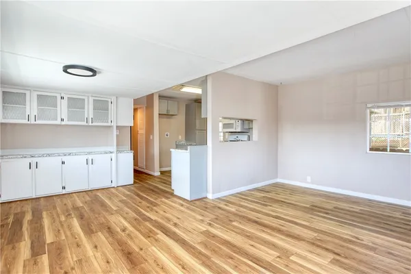 a view of empty room with wooden floor and windows