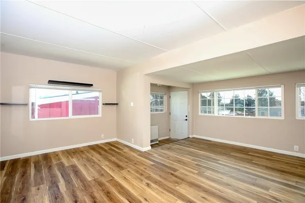 a view of a room with wooden floor and windows