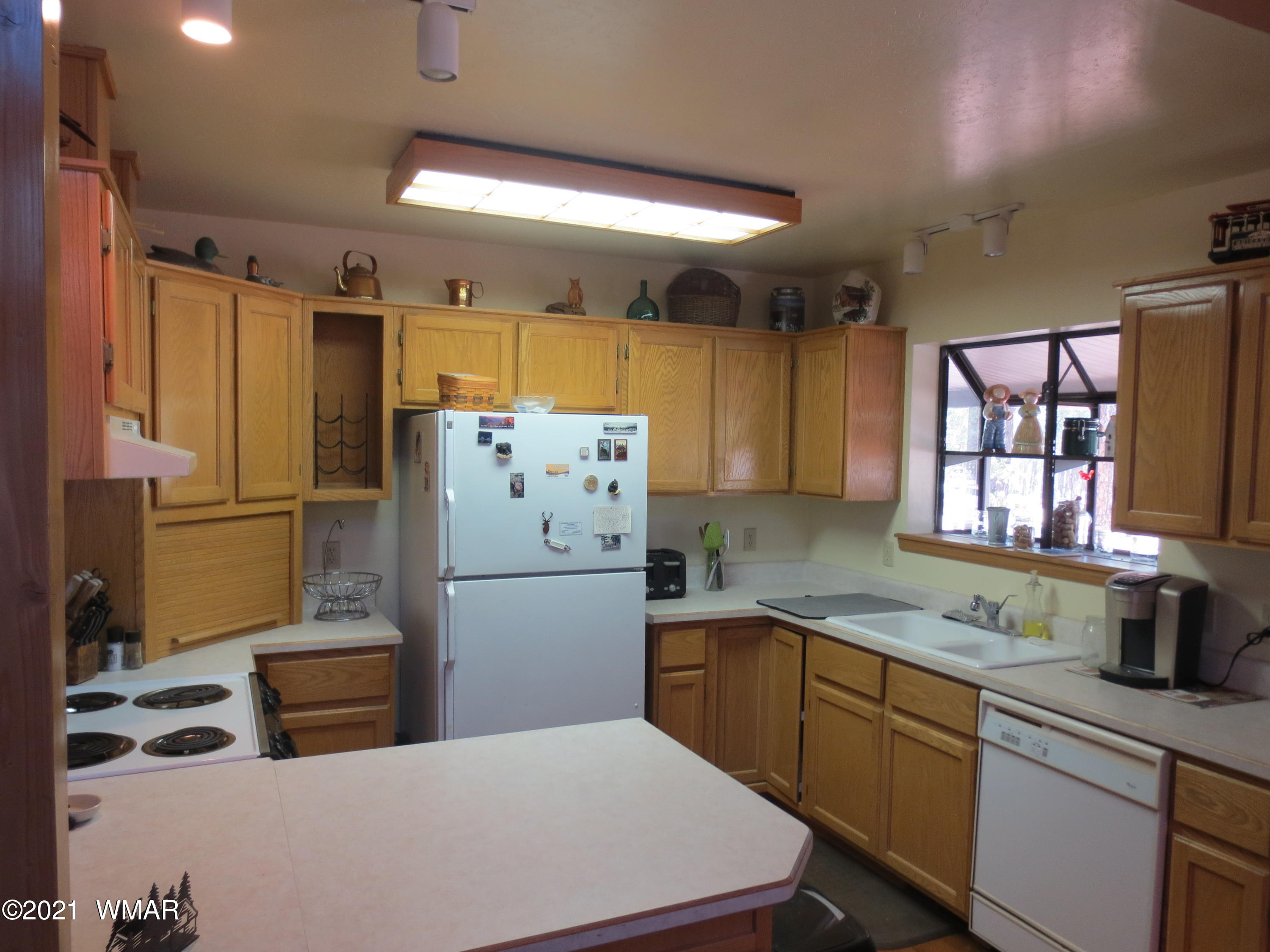 2970 Monica Road Overgaard, AZ 85933 - Photo 23 of 37 a kitchen with a refrigerator a sink and wooden cabinets