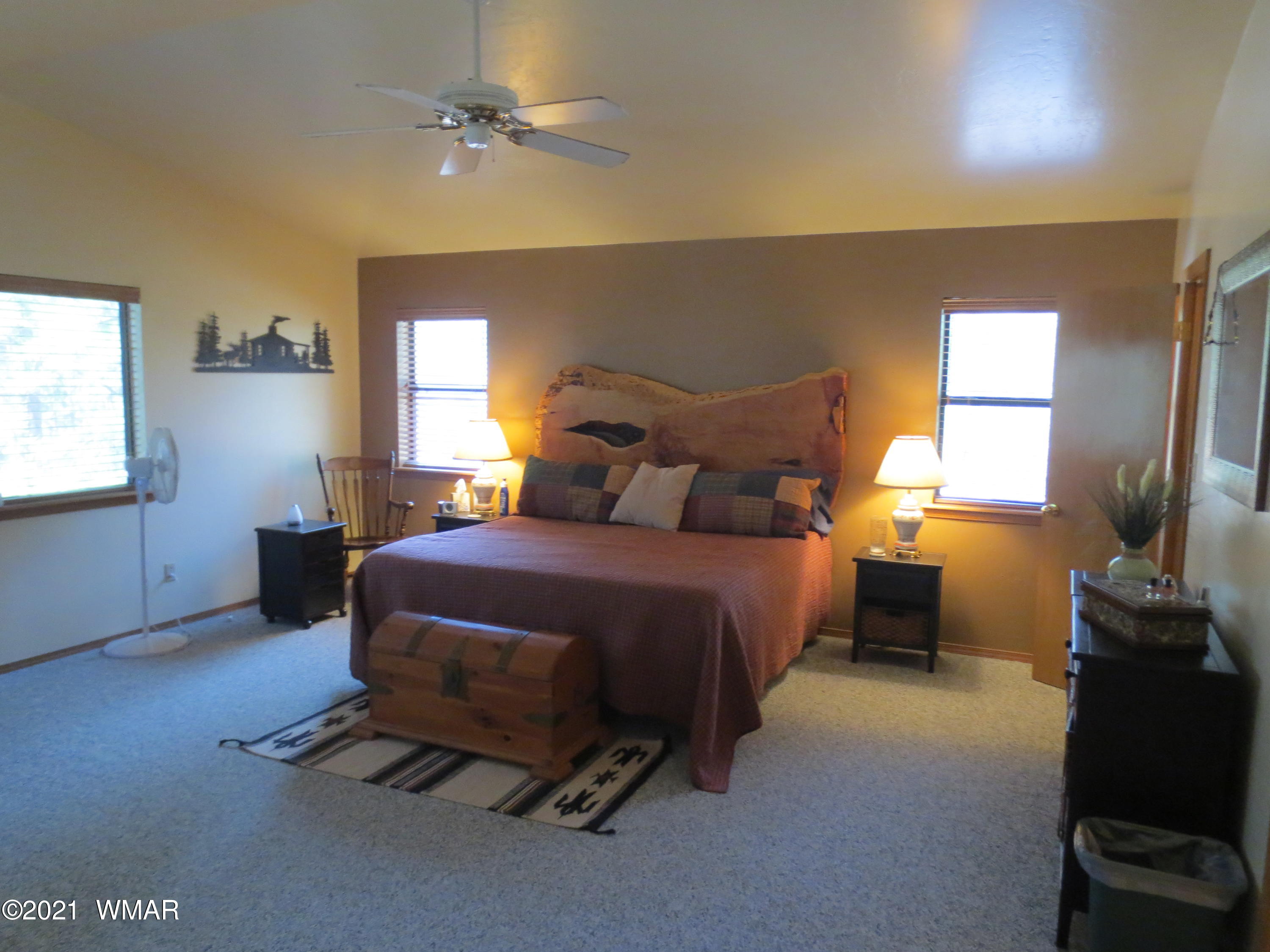 2970 Monica Road Overgaard, AZ 85933 - Photo 32 of 37 a bedroom with a bed and a chandelier