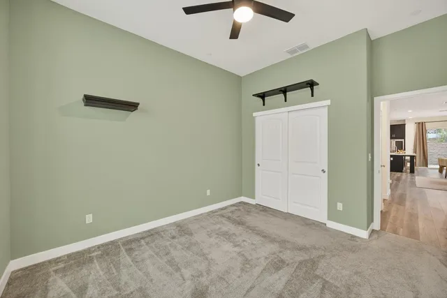 an empty room with closet and fan
