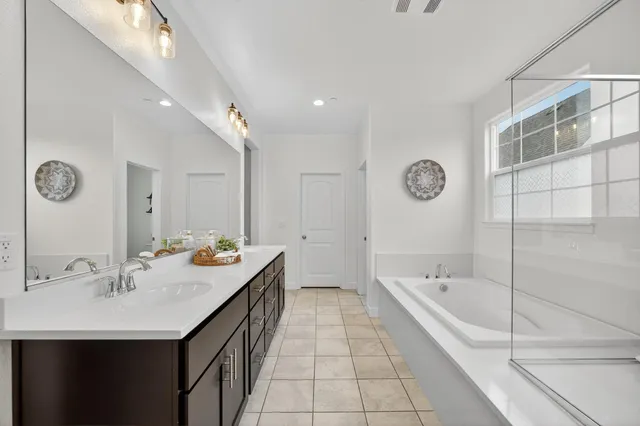 a bathroom with a tub sink and mirror