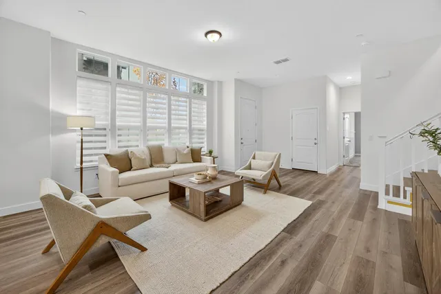a living room with furniture and a wooden floor