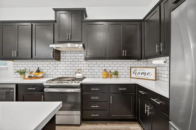 a kitchen with stainless steel appliances a sink stove and cabinets