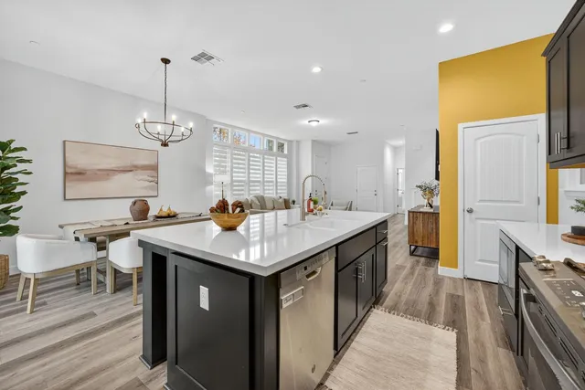 a kitchen with stainless steel appliances granite countertop a sink a counter space and wooden floor