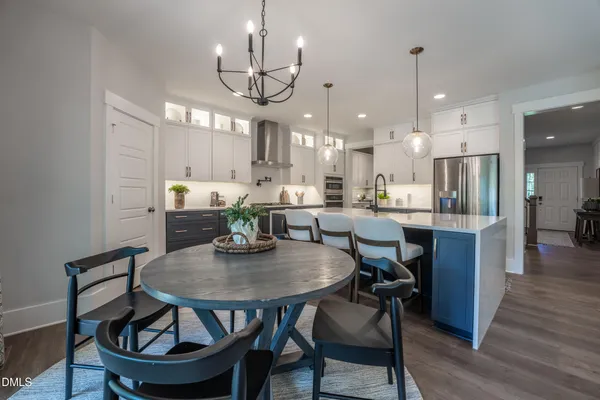 a view of a dining room with furniture a chandelier and wooden floor