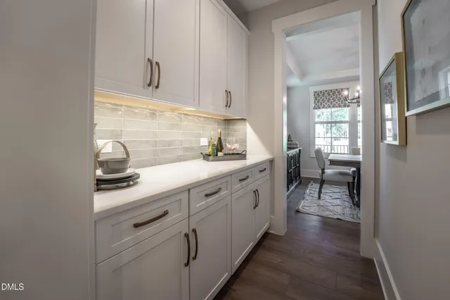 a kitchen with white cabinets and sink